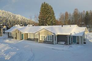 a house with a snow covered roof in the snow at Apartments Huili in Tahkovuori