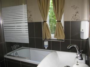 La salle de bains est pourvue d'un lavabo et d'une fenêtre. dans l'établissement Jókai Villa, à Siófok