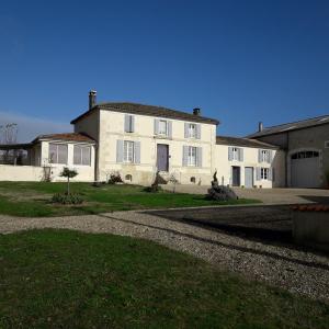 ein großes weißes Haus auf einem Hof in der Unterkunft L'En Haut des Vignes in Mérignac