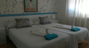 a bedroom with two beds with towels on them at Hostal Caminito in La Bañeza