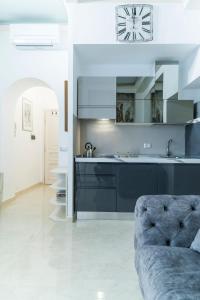 a kitchen with blue cabinets and a couch at Prinsi Apartments in Rome +77 photos