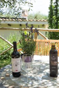 - deux bouteilles de vin et des verres sur une table dans l'établissement La Collina Degli Ulivi, à Forano