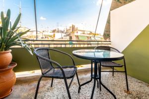 two chairs and a table on a balcony at Petaluda House 1 in Athens