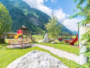 a park with a playground with a slide and a slideintend at Hotel Bacher in Riva di Tures