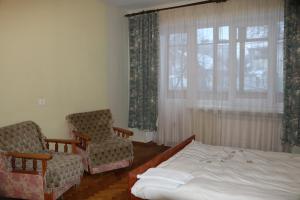 テルノーピリにあるАпартаменти біля озераのベッドルーム1室(ベッド1台、椅子2脚、窓付)