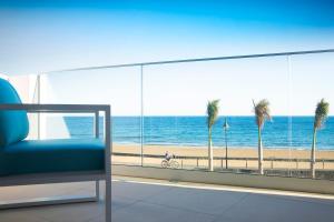 a room with a view of the beach and a chair at Hotel Lava Beach in Puerto del Carmen
