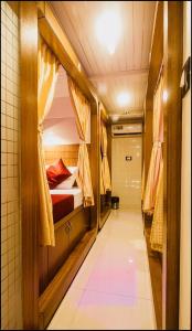 a small room with a bed and a corridor at Qubestay Airport Capsule Hotel & Hostel in Mumbai