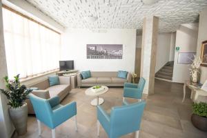 a living room with a couch and blue chairs at Hotel Croce del Sud in Cesenatico