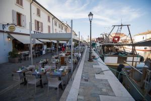 a restaurant with tables and chairs next to a canal at Hotel Croce del Sud in Cesenatico