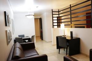 Hotel & Suites PF في مدينة ميكسيكو: غرفة معيشة مع أريكة وطاولة