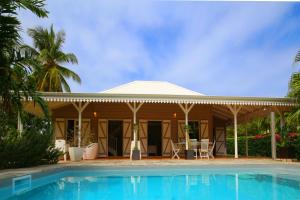 a house with a swimming pool in front of a house at Villa avec piscine au Cap Est (MQFR35) in Le François