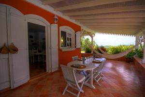 Un comedor con mesa y sillas y una ventana. en Villa avec piscine et vue mer (MQRO08), en Le Robert