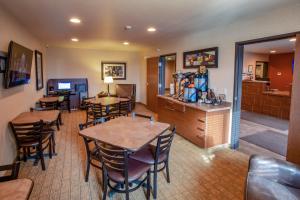uma sala de jantar com mesas e cadeiras e uma cozinha em My Place Hotel-Fargo, ND em Fargo