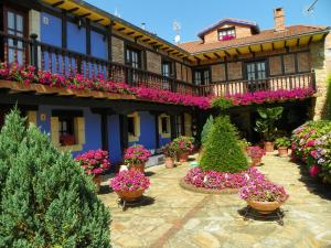 un patio de un edificio con macetas y flores en Posada Gema en Ubiarco