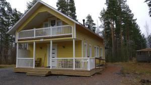 a yellow house with a porch and a balcony at Aurinkolinna 12 in Peräseinäjoki