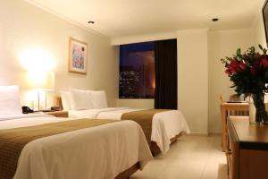 a hotel room with two beds and a window at Hotel PF in Mexico City