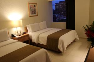 a hotel room with two beds and a window at Hotel PF in Mexico City