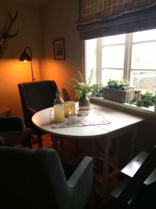 un tavolo con una bottiglia di succo d'arancia e una finestra di Ferienwohnung Alte Scheune a Egestorf