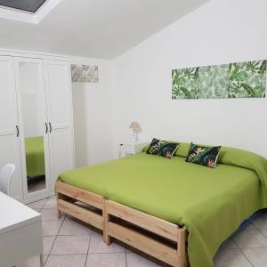 - une chambre avec un lit et une couette verte dans l'établissement Basilica San Gavino, à Porto Torres