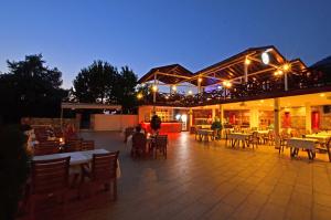 a restaurant with tables and chairs at night at Konfor Suite Otel in Oludeniz