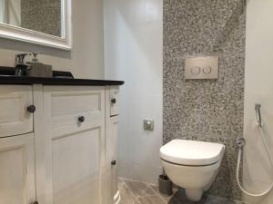 La salle de bains est pourvue de toilettes blanches et d'un lavabo. dans l'établissement Beautiful apartment Rue De La Croix Vieux Nice, à Nice