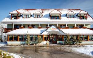 ein großes Gebäude mit einem schneebedeckten Dach in der Unterkunft Hotel reAktiv in Zreče