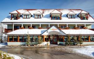 un grand bâtiment avec un toit recouvert de neige dans l'établissement Hotel reAktiv, à Zreče