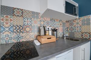 cocina con fregadero y azulejos en la pared en My Toul'House Morhange, en Toulouse