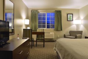 a hotel room with a bed and a desk at Hilltop Inn by Riversage in Billings