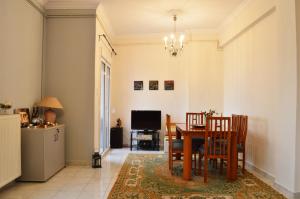 a dining room with a table and chairs and a television at Perfect View in Piraeus