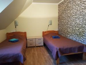 a bedroom with two beds and a stone wall at Märjamaa Hostel in Märjamaa