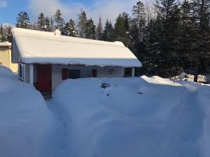 a snow covered house with a pile of snow in front of it at Chalet Le Semeur in Saint Elie