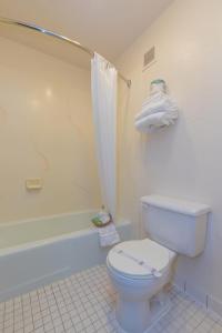 a bathroom with a white toilet and a shower at Motel 8 Rock Springs in Rock Springs