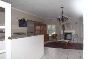 a kitchen and living room with a table and chairs at Fomo Lodge in Bellville