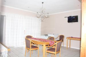 a dining room with a dining table and chairs at Fomo Lodge in Bellville