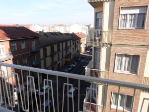 een balkon met stoelen en een straat met gebouwen bij ASTI LOVELY APARTMENT in Asti