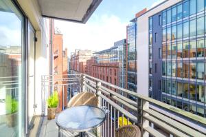 - un balcon avec une table et des chaises dans un bâtiment dans l'établissement Central City Apartment - Free Parking, à Belfast