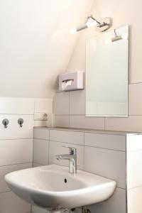 a white bathroom with a sink and a mirror at Königsberger in Ebergötzen