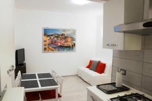 uma cozinha e sala de estar com um sofá e uma pintura na parede em A due passi dalla LANTERNA em Gênova