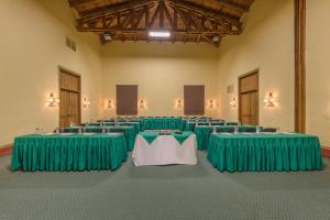 Habitación con filas de mesas y ropa de cama verde. en Tapalpa Country Club Hotel, en Tapalpa