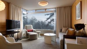 a living room with a couch and a large window at The Green Leaf, Niseko Village in Niseko