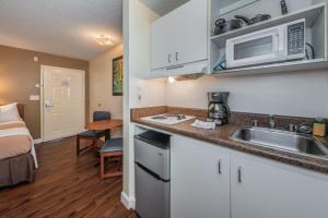 a kitchen with a sink and a microwave at Tampa Bay Extended Stay Hotel in Largo