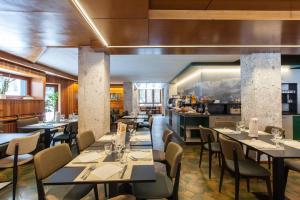 a restaurant with tables and chairs and a kitchen at Hotel Canin in Sella Nevea