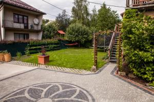 einen Hinterhof mit einem Garten mit einem Spielplatz in der Unterkunft Willa Szarotka in Rabka-Zdrój