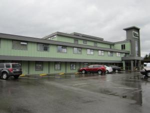 ein grünes Gebäude mit Autos auf einem Parkplatz in der Unterkunft Inn on the Harbour in Prince Rupert