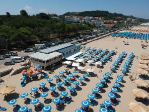 una vista aerea di una spiaggia con ombrelloni blu e bianchi di Verdemare a Torino di Sangro