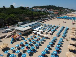 an aerial view of a beach with blue and white umbrellas at Verdemare in Torino di Sangro