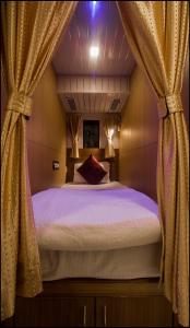 a bedroom with a large bed with curtains at Qubestay Airport Capsule Hotel & Hostel in Mumbai