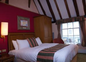 a bedroom with a large bed and a large window at The Catherine Wheel Wetherspoon Hotel in Henley on Thames