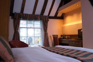 a bedroom with a bed and a window at The Catherine Wheel Wetherspoon Hotel in Henley on Thames